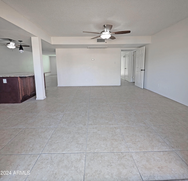 spare room with light tile patterned floors, a textured ceiling, and ceiling fan