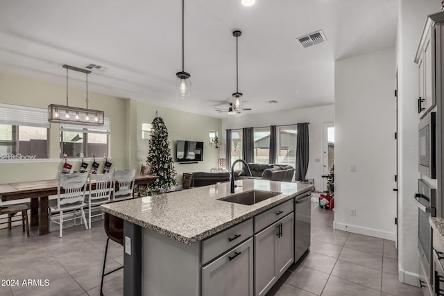 kitchen featuring a kitchen island with sink, sink, pendant lighting, and plenty of natural light