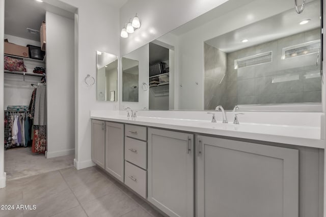 bathroom featuring a tile shower, vanity, and tile patterned floors