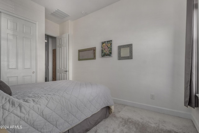 bedroom featuring light carpet and a closet