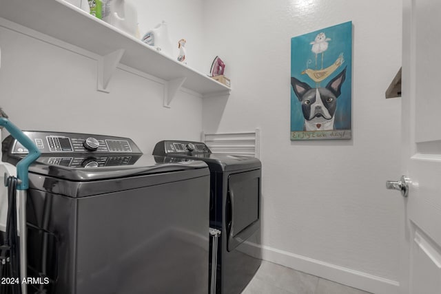 laundry area featuring light tile patterned floors and washer and clothes dryer