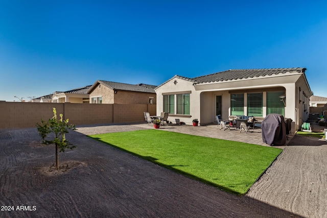 back of property with a patio area and a lawn