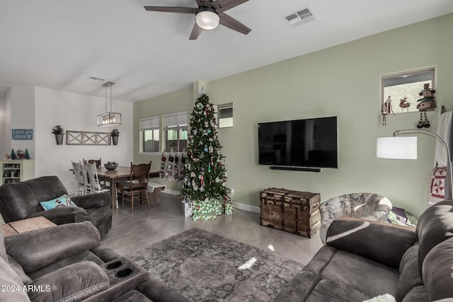 living room featuring tile patterned flooring and ceiling fan with notable chandelier