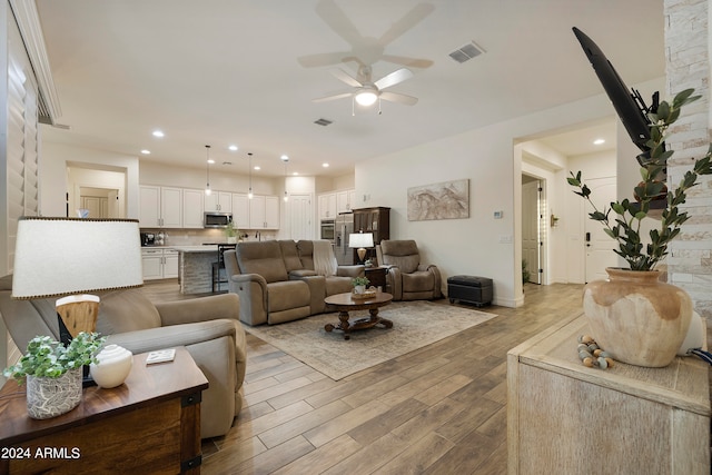 living room featuring light wood-type flooring and ceiling fan