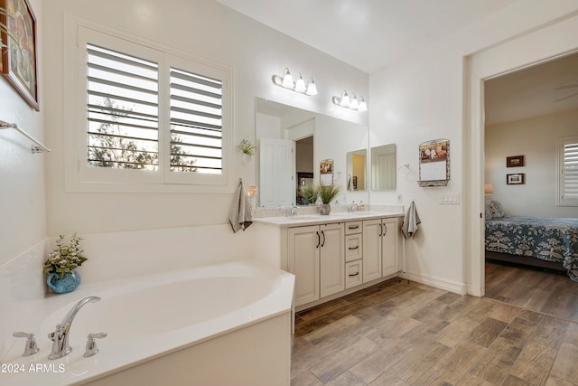 bathroom with vanity, a tub, and hardwood / wood-style floors