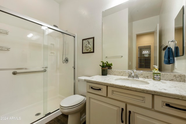 bathroom featuring hardwood / wood-style floors, an enclosed shower, vanity, and toilet