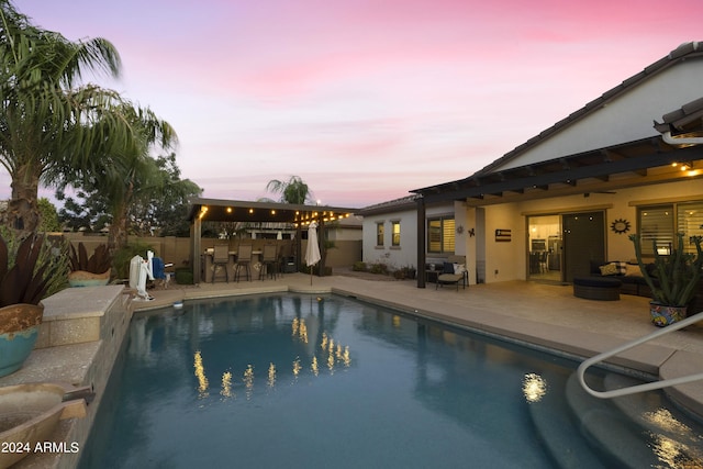 pool at dusk with a patio