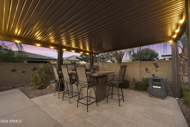 patio terrace at dusk featuring an outdoor bar