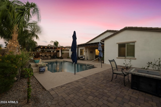 pool at dusk with a patio