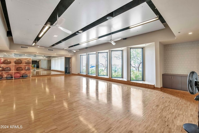 exercise room with ceiling fan and wood-type flooring