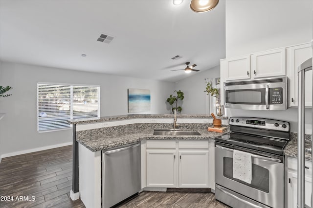 kitchen featuring white cabinets, sink, vaulted ceiling, appliances with stainless steel finishes, and dark hardwood / wood-style flooring