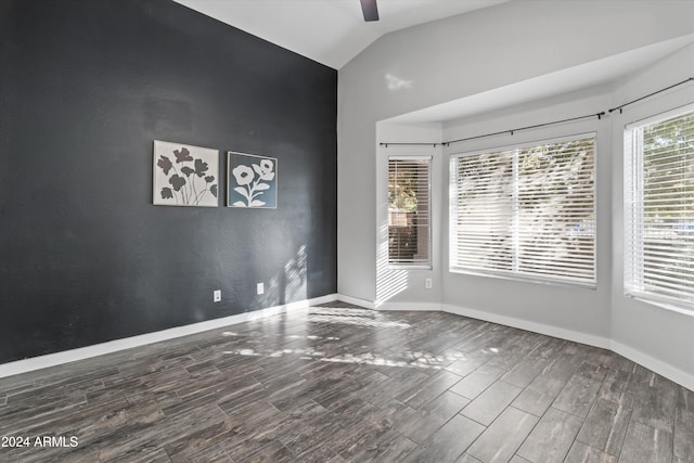 empty room with dark hardwood / wood-style floors, ceiling fan, and vaulted ceiling