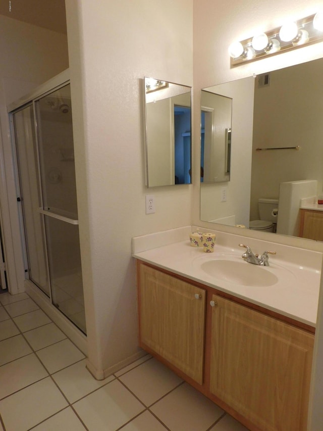 full bathroom with tile patterned flooring, a shower stall, toilet, and vanity