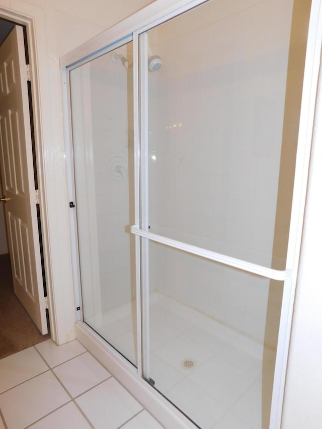 full bath with a shower stall and tile patterned flooring