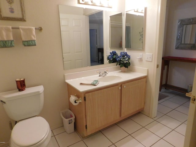 bathroom featuring toilet, vanity, and tile patterned flooring