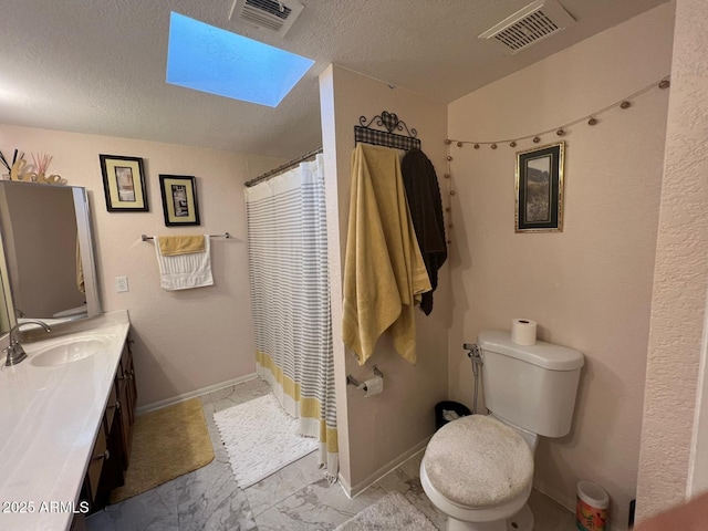 9060 N 47th Ln, Glendale, AZ 85302 - full bath featuring a skylight, toilet, vanity, a textured ceiling, and marble finish flooring