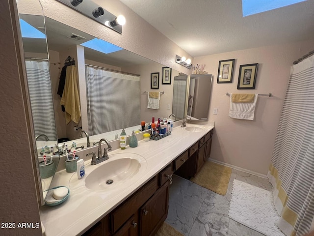 9060 N 47th Ln, Glendale, AZ 85302 - full bathroom featuring double vanity, a textured ceiling, and baseboards