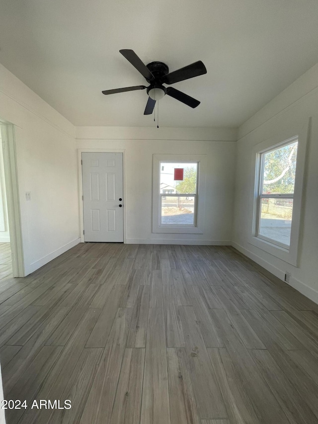 spare room with ceiling fan, plenty of natural light, and hardwood / wood-style floors