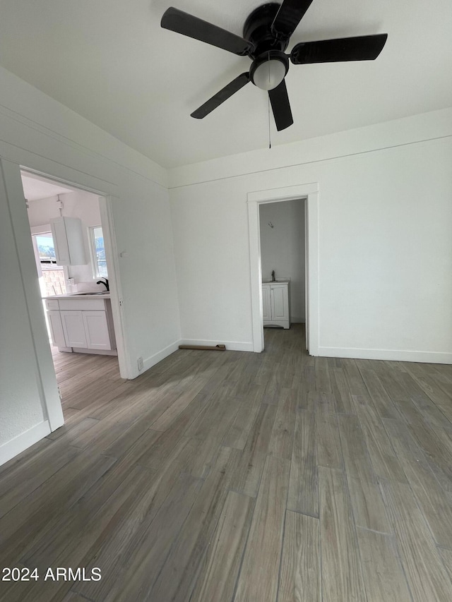 empty room with ceiling fan, hardwood / wood-style floors, and sink