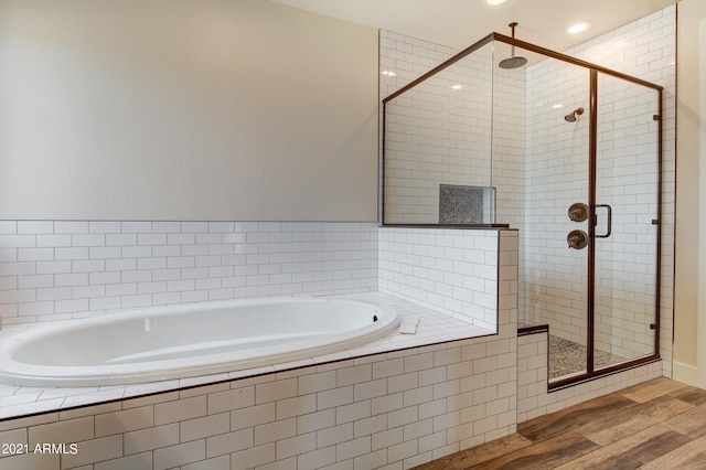 bathroom featuring wood-type flooring and plus walk in shower