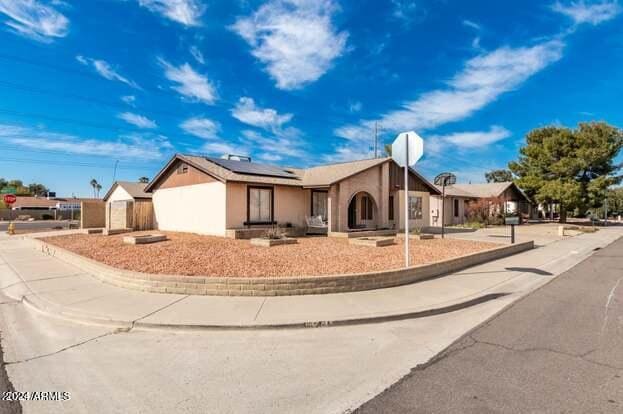 single story home featuring solar panels