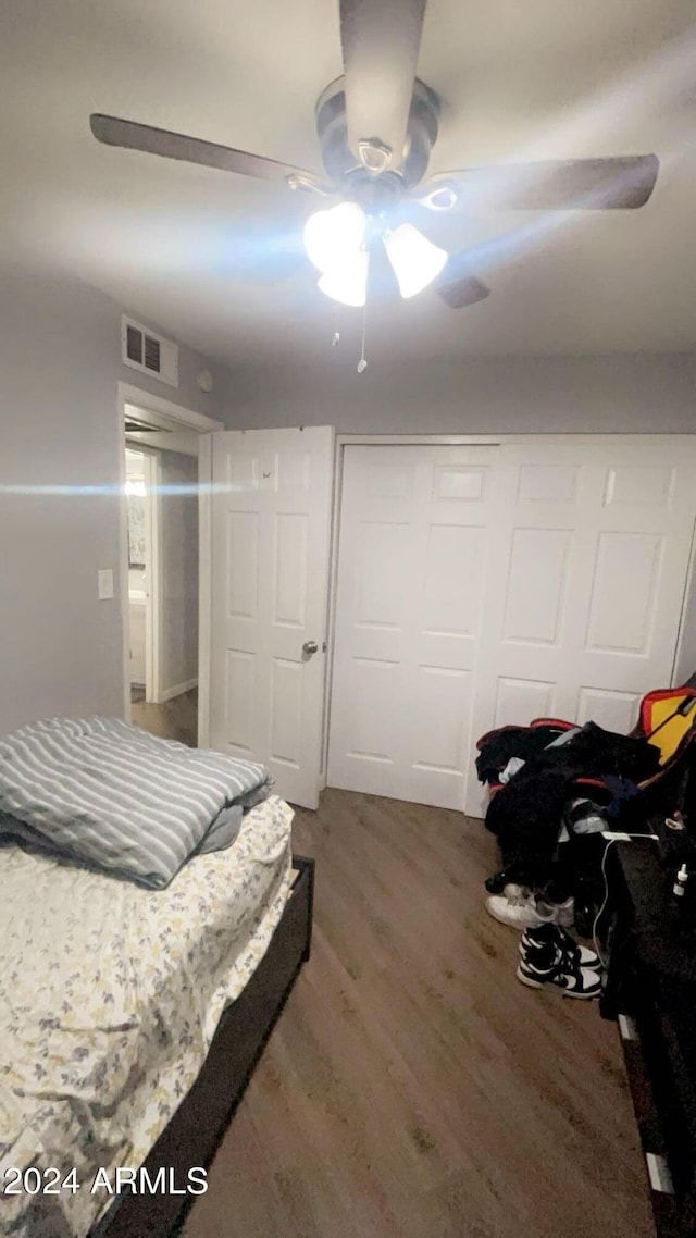 bedroom featuring hardwood / wood-style floors, a closet, and ceiling fan