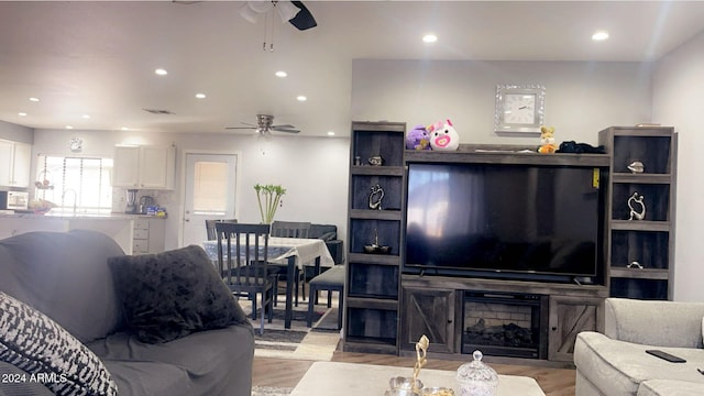 living room featuring ceiling fan and light wood-type flooring