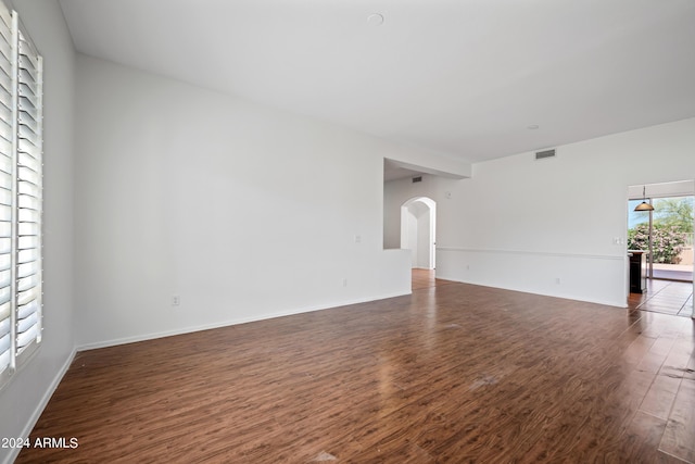 16914 E Britt Ct, Fountain Hills, AZ 85268 - unfurnished living room featuring baseboards, visible vents, wood finished floors, and arched walkways