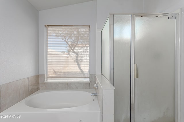 bathroom with vaulted ceiling and independent shower and bath