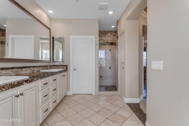 bathroom featuring vanity, decorative backsplash, tile patterned floors, and a shower with shower door