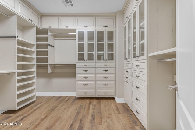 walk in closet with light wood-type flooring