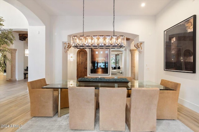 dining space featuring ornate columns and light hardwood / wood-style floors