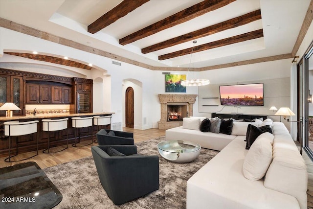 living room with beam ceiling and light wood-type flooring