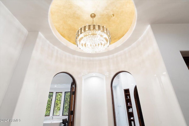 room details with a raised ceiling and an inviting chandelier