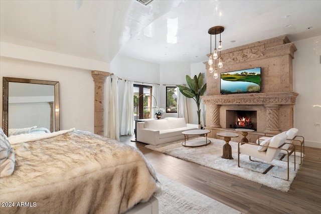 bedroom featuring a high end fireplace and dark wood-type flooring