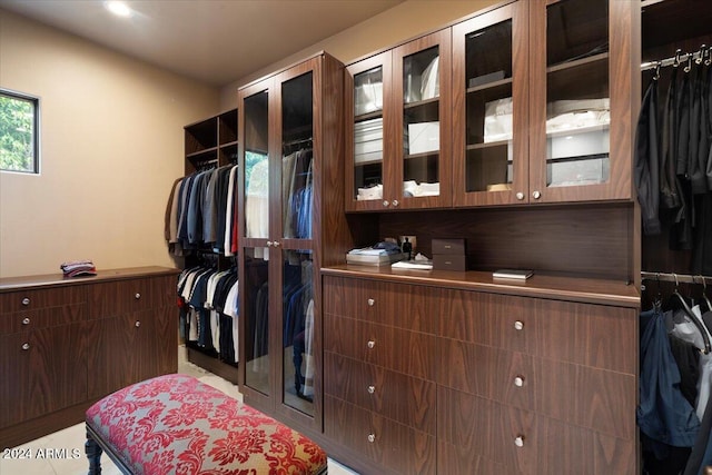 walk in closet with light tile patterned floors