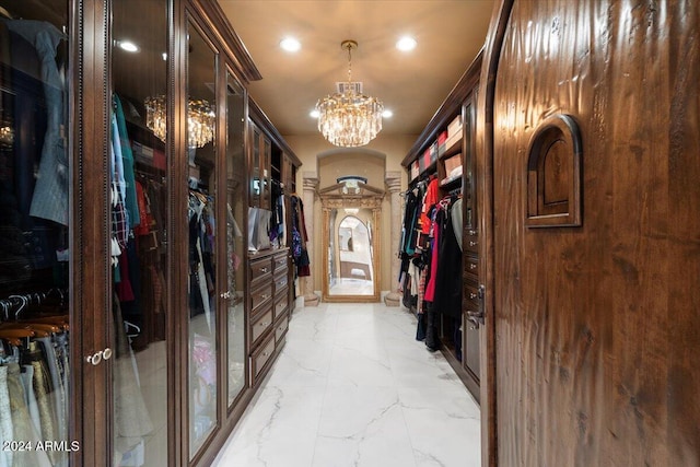 walk in closet featuring a notable chandelier