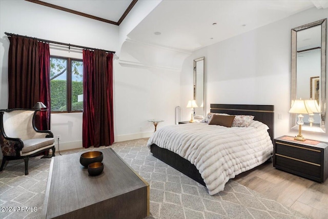 bedroom featuring light hardwood / wood-style flooring and crown molding