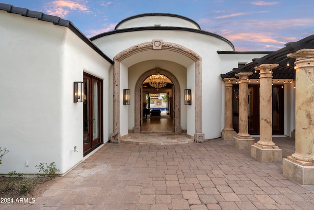 exterior entry at dusk with a patio