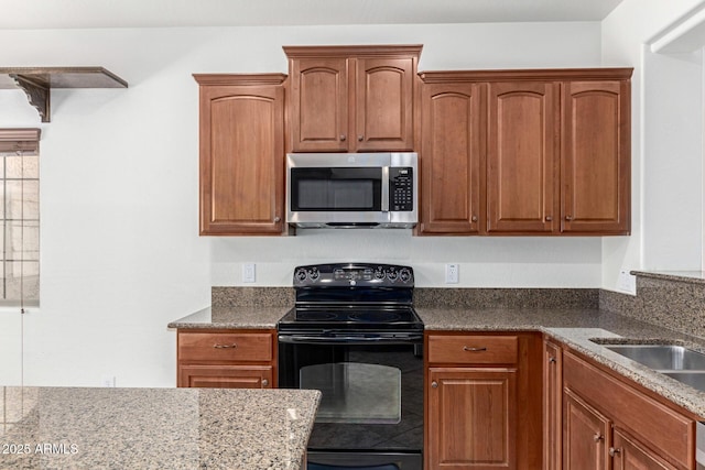 19319 E Thornton Rd, Queen Creek, AZ 85142 - kitchen with stainless steel microwave, black / electric stove, dark stone counters, and brown cabinets