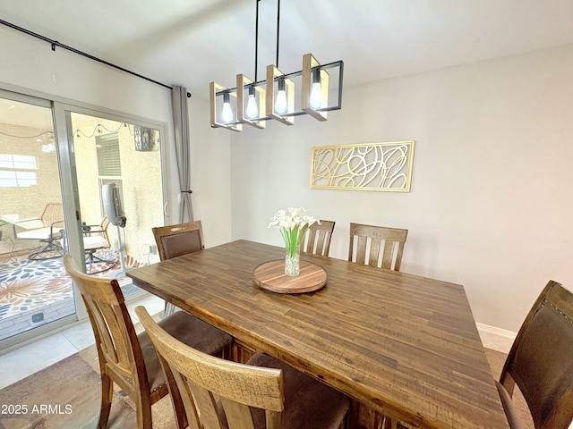 tiled dining area featuring a chandelier