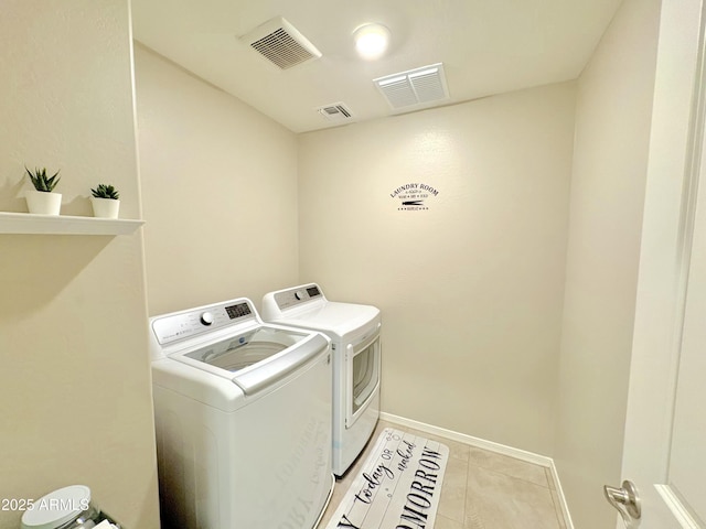 washroom featuring washing machine and clothes dryer and light tile patterned floors