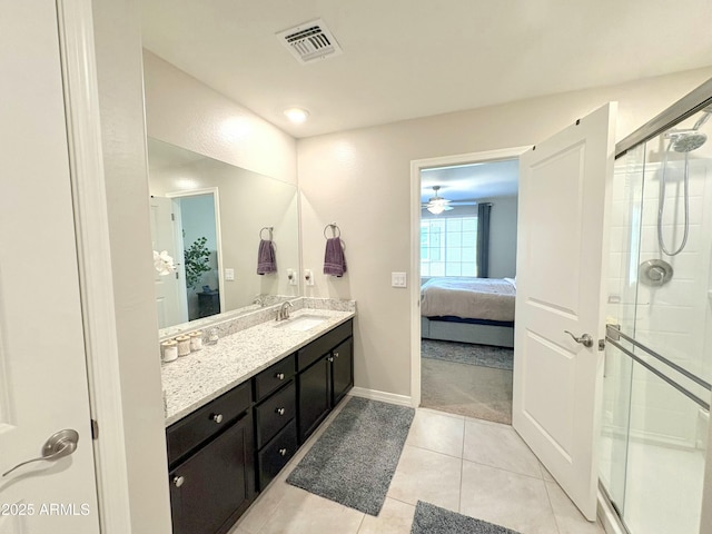 bathroom featuring a shower with door, vanity, and tile patterned floors