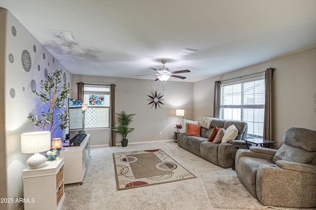 living room featuring ceiling fan, light carpet, and a wealth of natural light