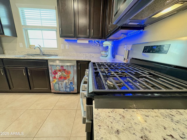 kitchen with light tile patterned flooring, stainless steel appliances, sink, and dark brown cabinets