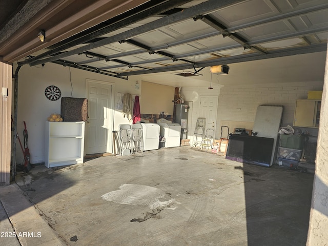 garage featuring washer and clothes dryer, a garage door opener, and gas water heater