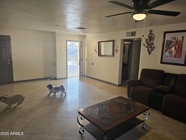 tiled living room with ceiling fan and a textured ceiling