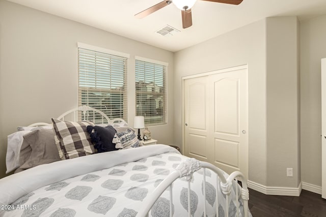 bedroom with dark hardwood / wood-style flooring, a closet, and ceiling fan