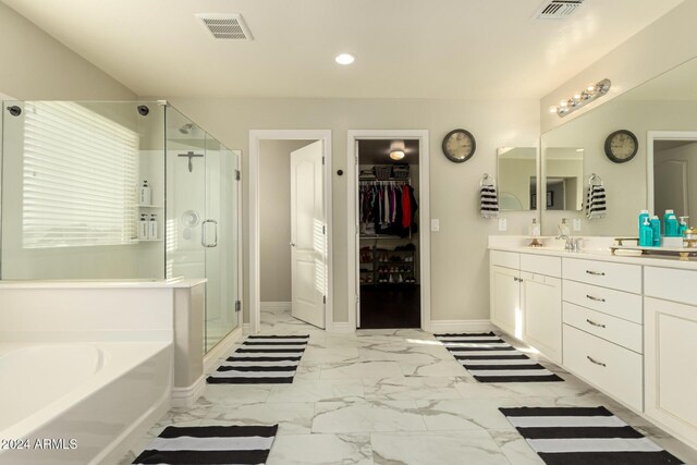 bathroom with vanity and shower with separate bathtub