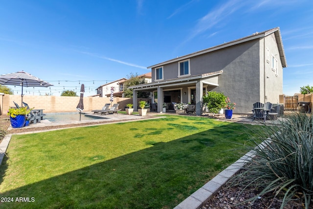 rear view of property with a yard and a patio